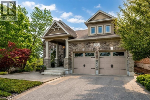 Backyard patio with outdoor seating and a view of the brick house. - 125 Woolner Trail, Kitchener