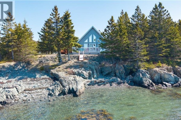 Front view of a grey A-frame house with a white deck and several triangular windows. - 1250 Route 172, L Etete