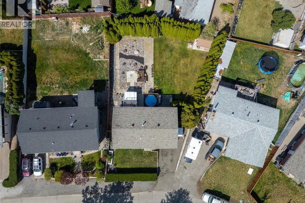 Aerial view looking down on the backyard with a patio, pool, and surrounding fences. - 1254 Heustis Drive, Ashcroft