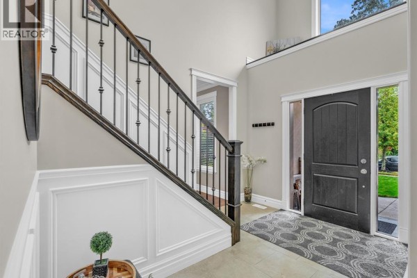 View of a staircase with dark wood steps and railing, surrounded by beige walls and white wainscoting. - 1255 Maple, Lasalle