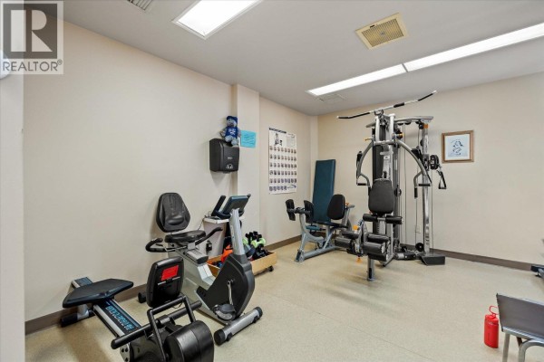 Fitness room with cardio machines, weight machines, and an exercise mat. - 1255 Raymer Avenue Unit# 493, Kelowna