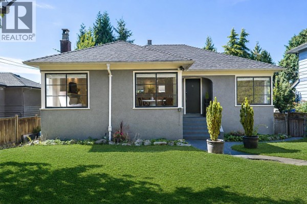 Front view of a grey house with a large green lawn and walkway. - 1258 Jefferson Avenue, West Vancouver