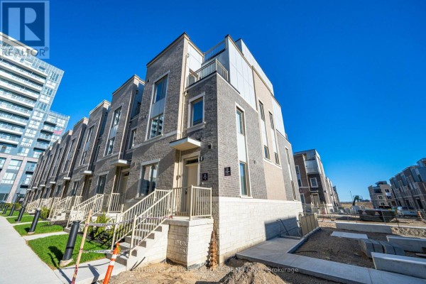 Street view of a townhouse development with a modern aesthetic and brick exteriors under a blue sky. - 126 - 30 Almond Blossom Mews, Vaughan