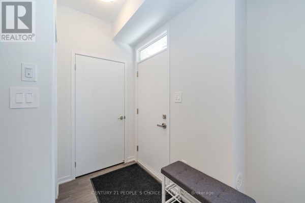 Bright interior foyer with white walls, grey laminate flooring, and two doors. - 126 - 30 Almond Blossom Mews, Vaughan