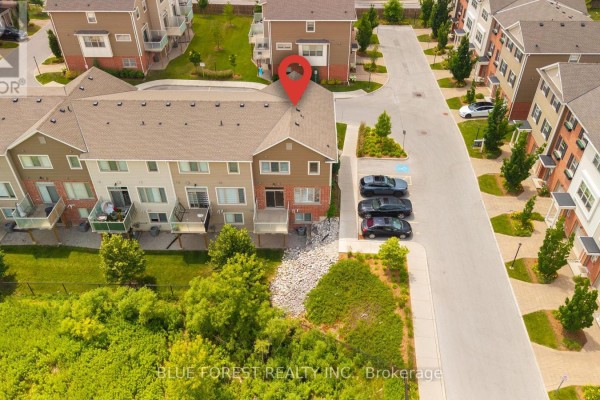 Aerial view of a townhouse complex with green landscaping and parked cars. - 126 - 3025 Singleton Avenue, London South