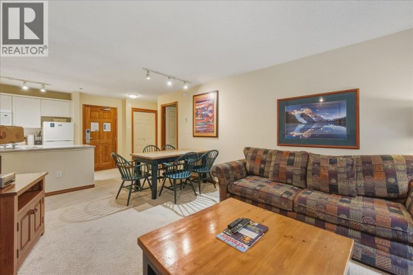 View of The Aspens buildings from a snowy slope with skiers and evergreen trees. - 126 4800 Spearhead Drive, Whistler