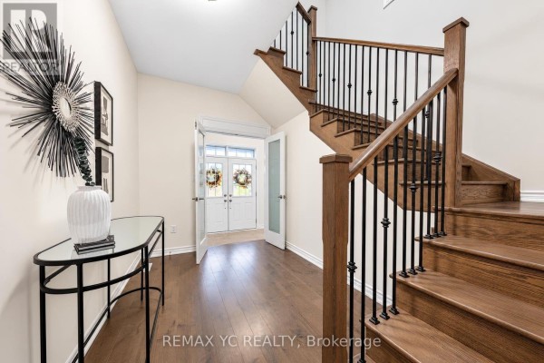 Foyer with dark hardwood floors, a staircase with dark wood treads and black spindles. - 126 Durham Avenue, Barrie