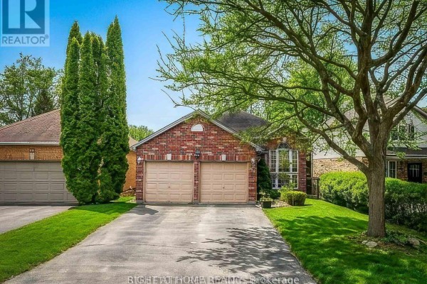 Side view of house with driveway and tall trees - 126 Meadowridge Road, London North