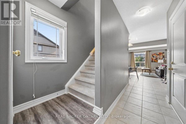 Aerial view of a street with multiple townhouses, parked cars, and landscaping. - 126 Parkinson Crescent, Orangeville