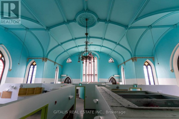 Interior view of vaulted blue ceiling with chandeliers and arched windows. - 126 Wellington Street, Kingston