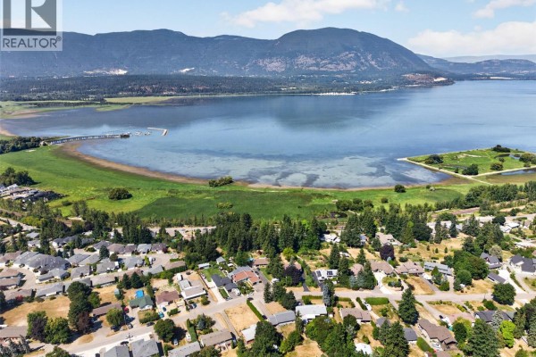 Top-down aerial view of a single-story house with a gray roof and surrounding trees. - 1260 16 Street Ne, Salmon Arm