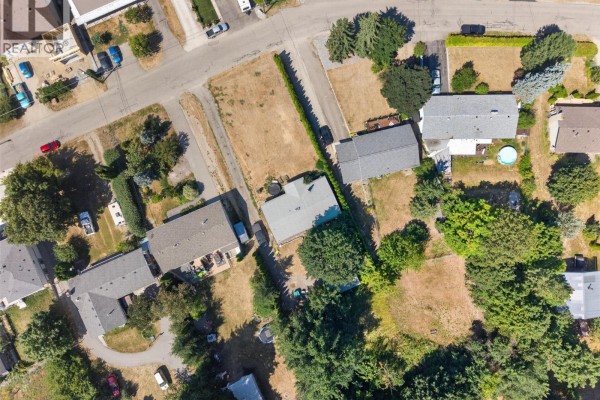 Aerial view of a suburban neighborhood with a large lake and distant mountains. - 1260 16 Street Ne, Salmon Arm