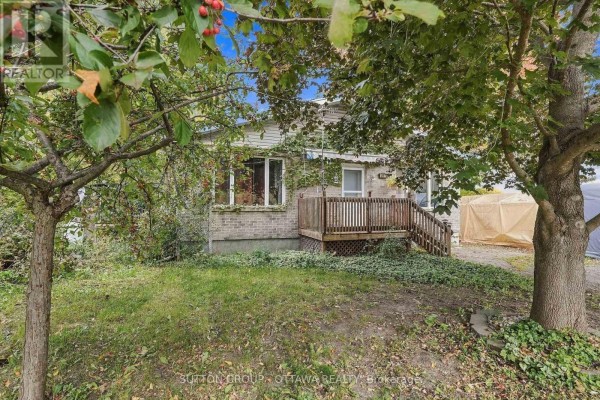 View of the residential property from across the lawn, featuring mature trees. - 12615 County 28 Road, South Dundas