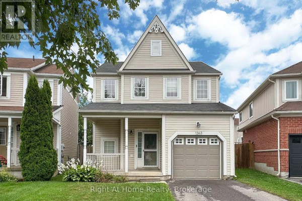 Front view of a beige two-story house with a prominent gable and white trim. - 1263 Gyatt Crescent, Oshawa