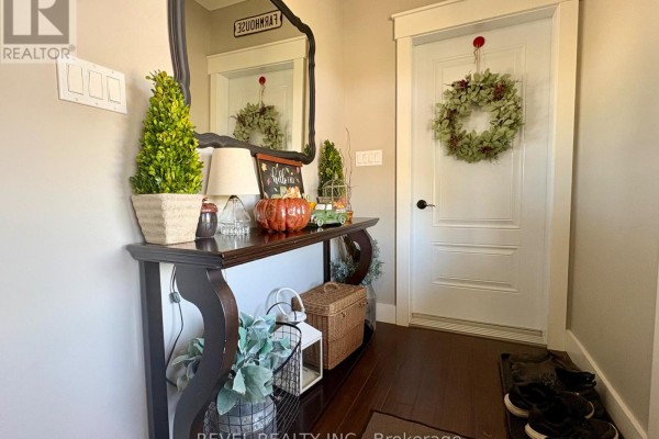 Entryway console table with decorative pumpkins and a white door with a wreath. - 1267 4 & 5 Concession, Cochrane