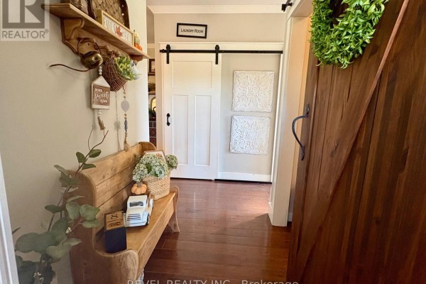 Hallway with a wooden bench, decorative items, and a sliding barn door to laundry room. - 1267 4 & 5 Concession, Cochrane