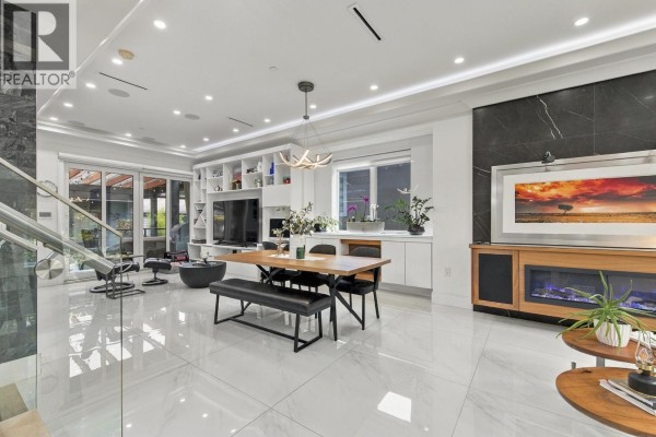 Open-concept living and dining area with white marble floors and modern furniture. - 1267 E 53rd Avenue, Vancouver