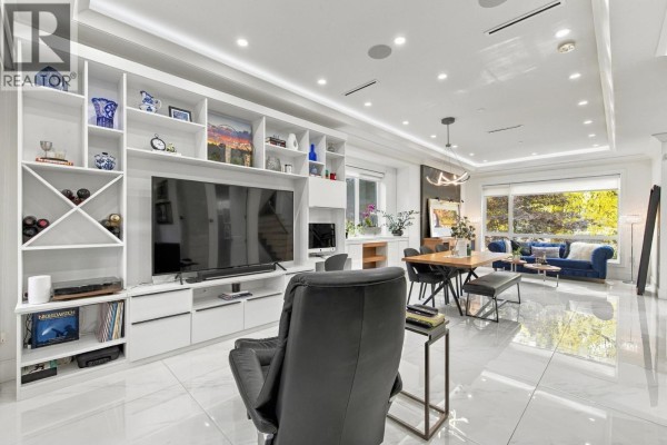 Spacious open-concept living and dining room with built-in shelving and entertainment unit. - 1267 E 53rd Avenue, Vancouver