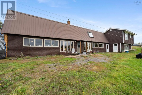 Rear view of the duplex with a long wall of windows and a dark brown shingled exterior. - 1268 Plains Road, Debert