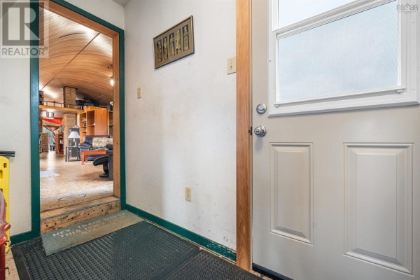 Interior view looking into a room from a doorway with a white door and a dark green mat. - 1268 Plains Road, Debert