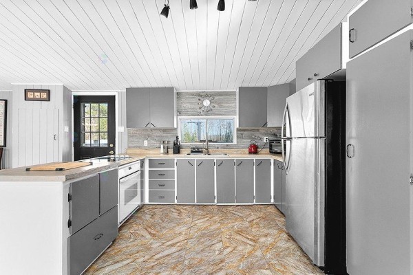 Interior view of a room with large windows, grey paneled walls, white trim, and light beige tiled flooring. - 127 Ch. Alie, Gracefield