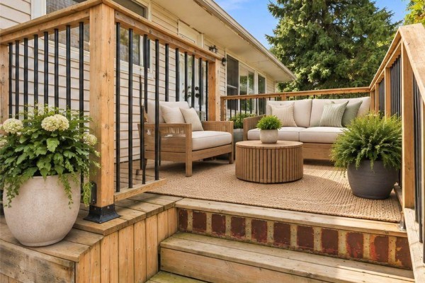 Outdoor seating area on a wooden deck with chairs, a sofa, and a coffee table. - 127 Coleman Crescent, Scugog