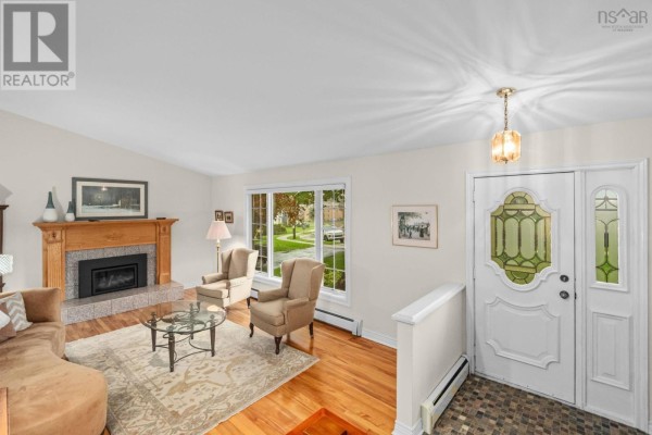 Living room with fireplace, bay window, and a double front door with leaded glass. - 127 Evans Avenue, Halifax
