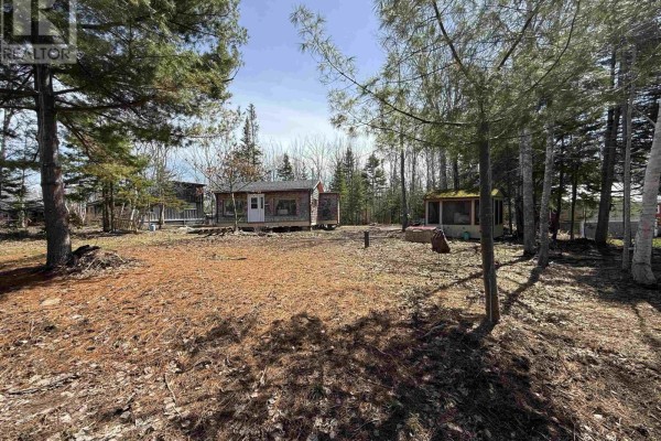 Aerial view of a 15,000 sq ft lot with a house, a shed, and trees near the water. - 127 Fieldwood Lane, Brule Shore
