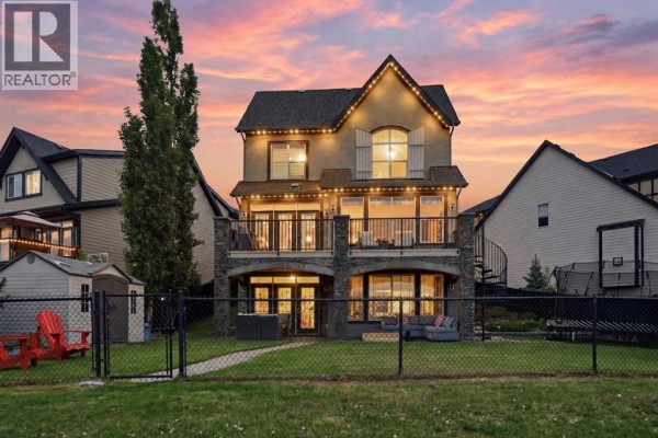 Open concept kitchen with dark wood cabinets, granite island, and dining area. - 127 Marquis Grove Se, Calgary