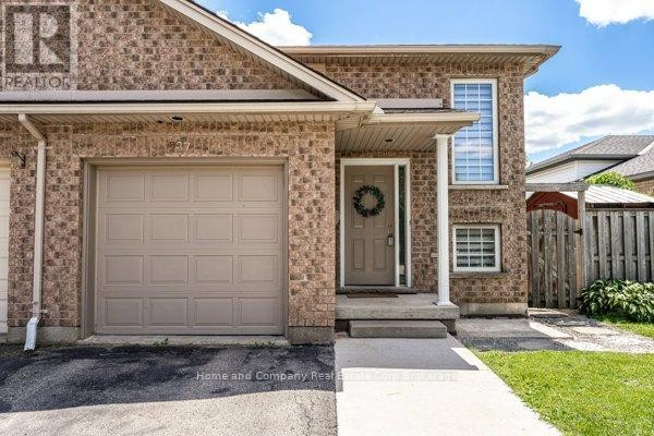 Backyard with a wooden fence, trampoline, fire pit, and garden bed. - 127 Walsh Crescent, Stratford