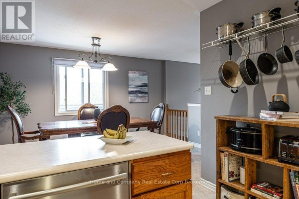 Kitchen with wooden cabinets, white appliances, pot rack, and open shelving - 127 Walsh Crescent Stratford