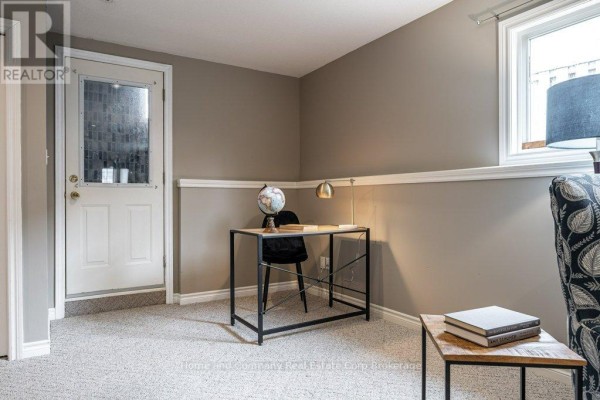 Honey wood cabinets, white stove, double sink, and microwave in kitchen - 127 Walsh Crescent Stratford