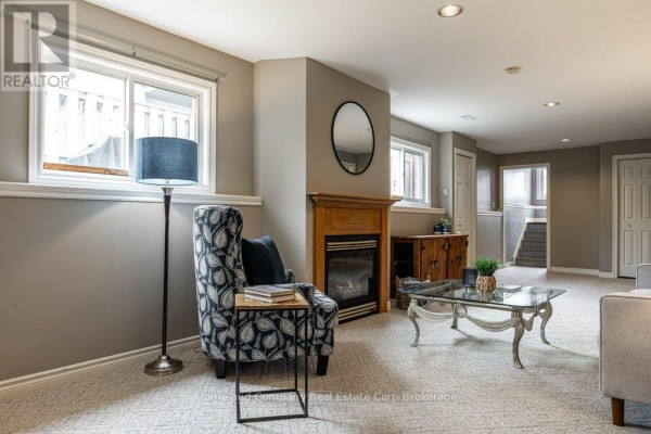 Living room with sofa, armchair, coffee table, bookshelf and shower enclosure visible - 127 Walsh Crescent Stratford