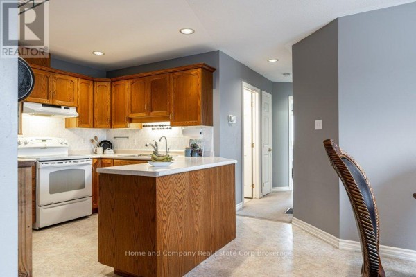 Brick townhouse exterior with attached garage, front door, and walkway - 127 Walsh Crescent Stratford