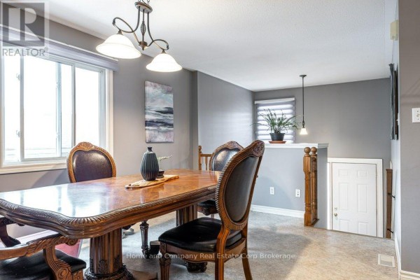Kitchen with wood cabinets, island, and white appliances - 127 Walsh Crescent Stratford
