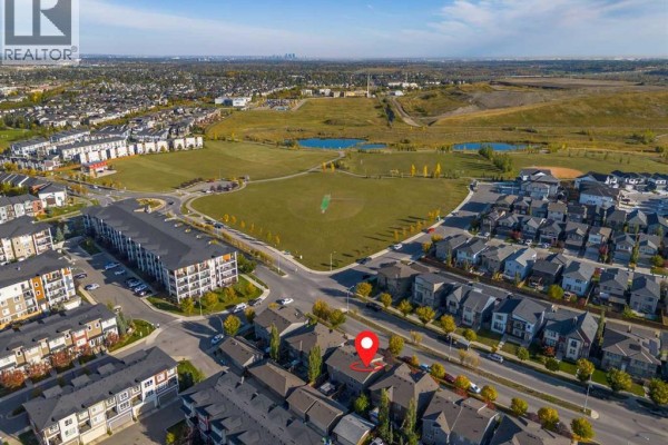 Aerial view of a Calgary neighbourhood showing duplexes, apartment buildings, and a large park with ponds. - 1270 Walden Drive Se, Calgary