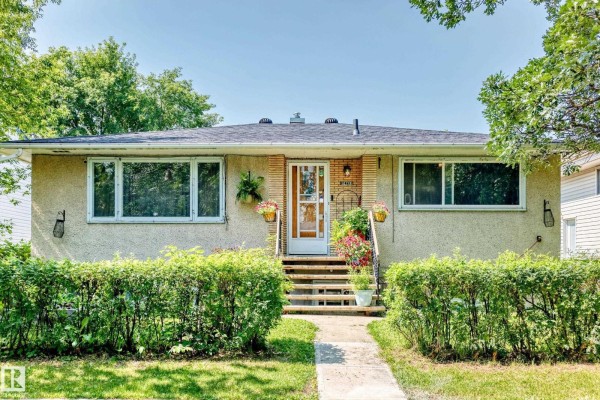 The main entrance of the duplex features a glass-paneled door with a tiled accent wall. - 12718 126 St Nw, Edmonton