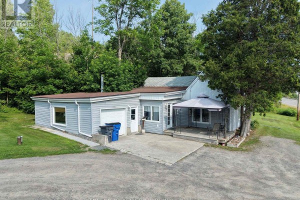 Front view of light grey house with attached garage and covered patio. - 1272 Lakeshore Road, Temiskaming Shores