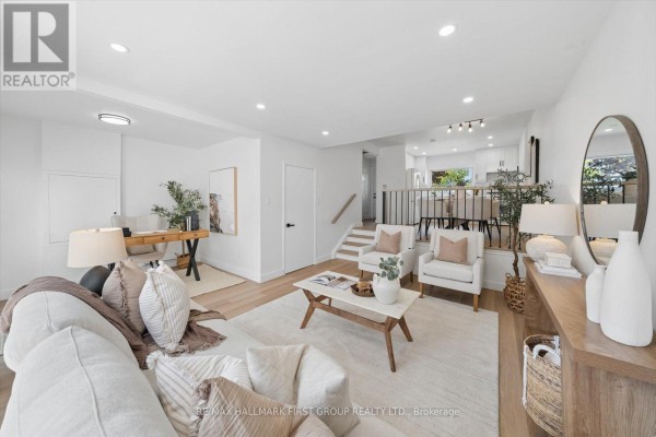 Living room with white sofas, a marble coffee table, and a wooden desk. - 128 - 30 Venetian Crescent, Toronto