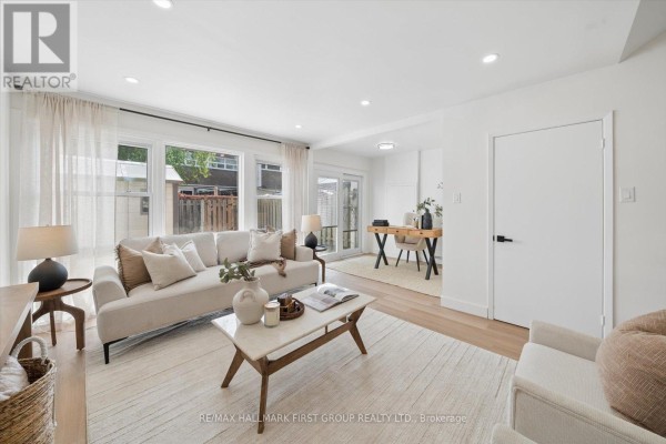 Spacious living room with large windows, a sectional sofa, and a desk area. - 128 - 30 Venetian Crescent, Toronto