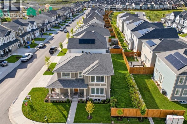 Aerial view of a suburban neighborhood with rows of houses and a street. - 128 Cityside Crescent Ne, Calgary