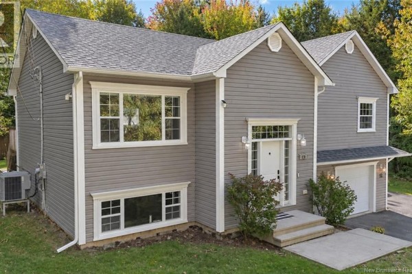 Front facade of a grey house with white trim, featuring a white front door and windows on two levels. - 128 Country Wood Lane, Richibucto Road