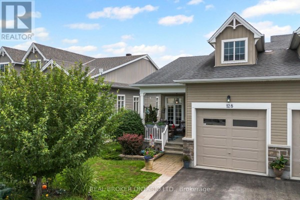 Entrance to townhouse 128 with covered porch, stone accents, and garage. - 128 George Street W, North Grenville