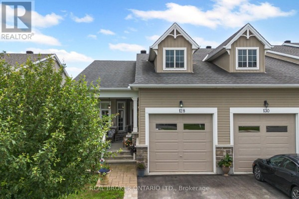 Facade of townhouse 128 and 130, beige siding, stone accents, and garages. - 128 George Street W, North Grenville