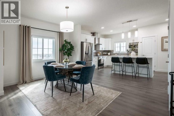 Living room with fireplace, modern furniture, large rug, and windows. - 128 Heartland Street, Cochrane