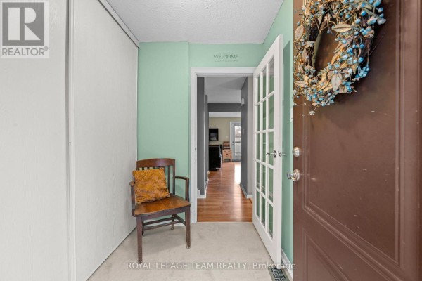 Interior entryway with light green walls, a sliding closet, and a wooden chair. - 128 Mcclintock Way, Ottawa