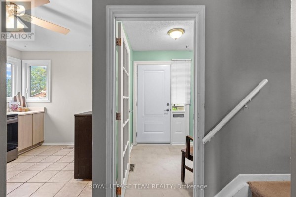 View from hallway through glass doors to entryway and front door. - 128 Mcclintock Way, Ottawa