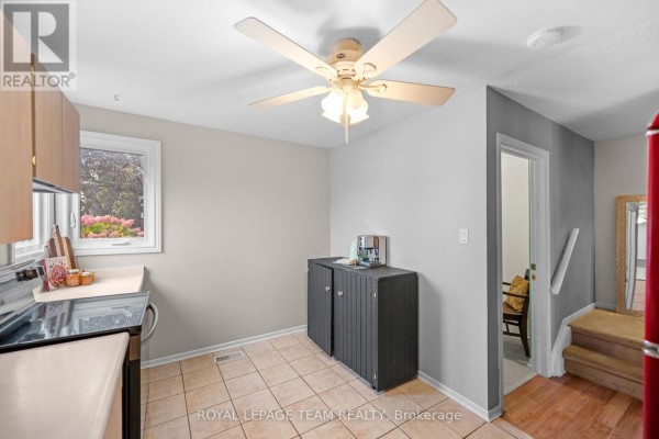 Kitchen area with a coffee station, dark cabinet, tiled floor, and entrance to hallway. - 128 Mcclintock Way, Ottawa
