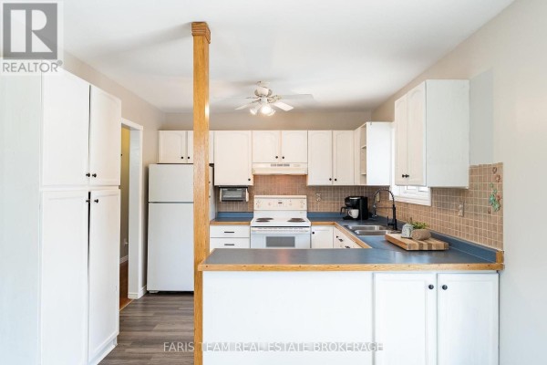 Wood-paneled room with desk, chairs, double doors, and sliding glass doors to another room. - 12804 County Road 16, Severn