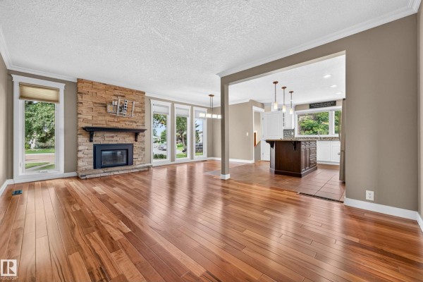 Kitchen view showcasing the island, white cabinets, granite countertops, and stainless steel appliances. - 12819 45 St Nw, Edmonton